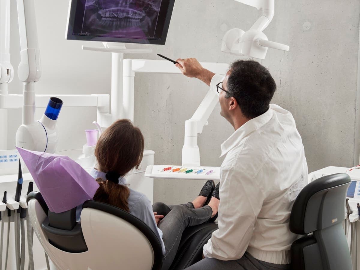 Praticien commentant une radiographie avec un patient